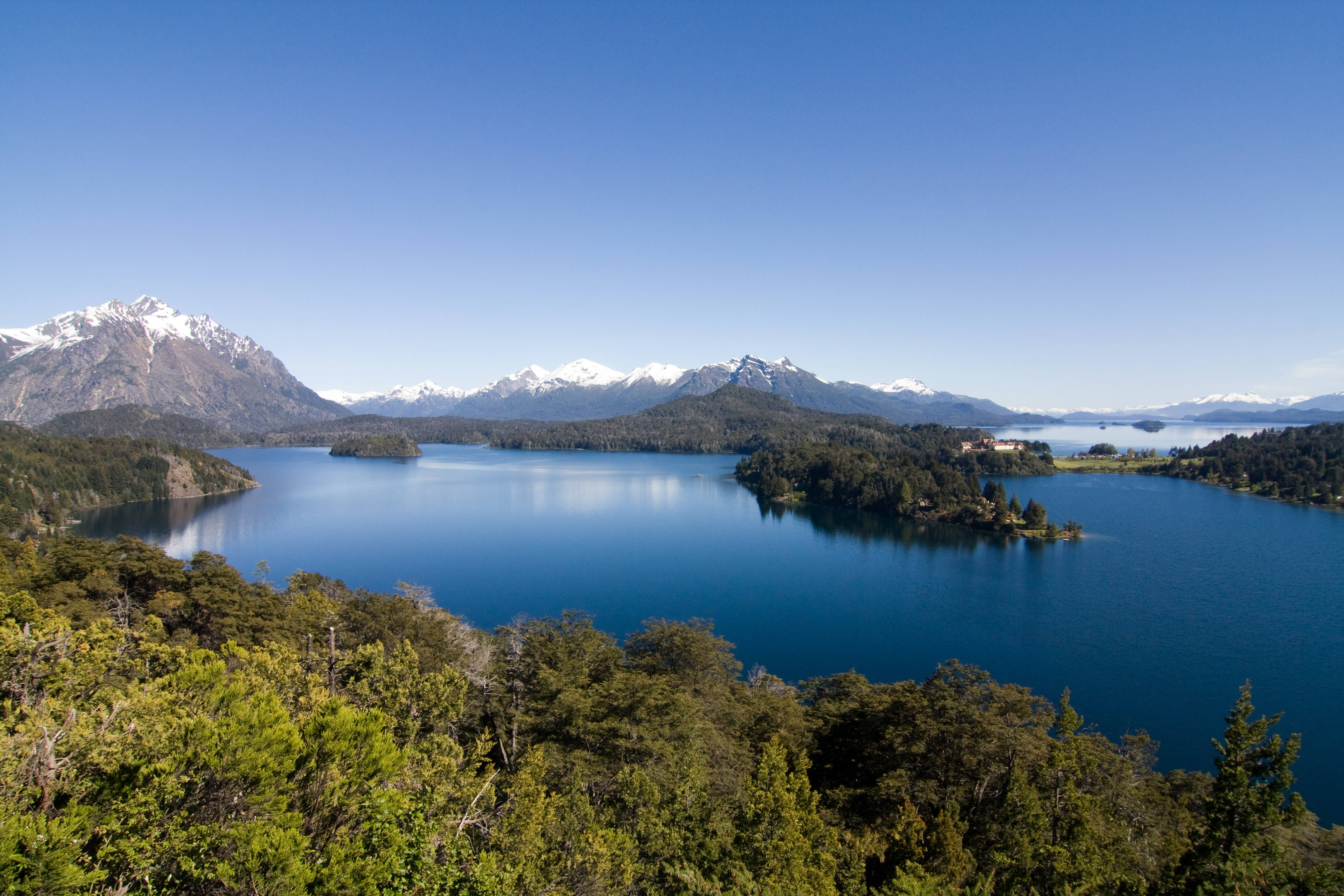 a lake with snowy mountains all around.