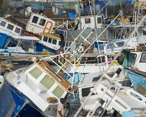 fisher boats piled on top of each other after a storm.