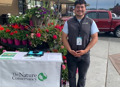 A face-to-face fundraiser stands beside his canvasing table.
