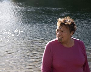 A person stands next to a body of water.