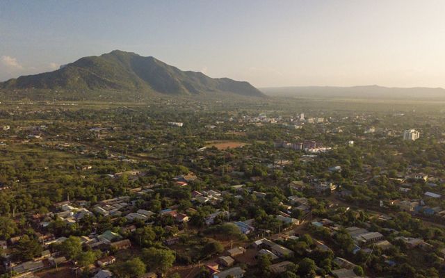An aerial view of a town with mountains in the background.