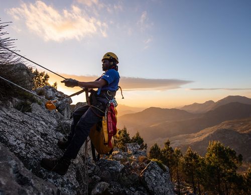 rope technician hanging on cliff 
