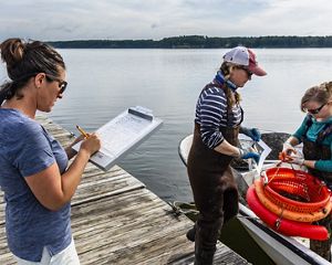 The Nature Conservancy's Alix Laferriere (left) records information with SOAR program participants Krystin Ward of Choice Oysters and Laura Brown (right) of Fox Point Oysters on the University of New Hampshire's JEL Lab dock on Great Bay in Durham, New Hampshire.