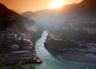 View from a high vantage point looking at a river that stretches between mountains and hillsides filled with buildings.