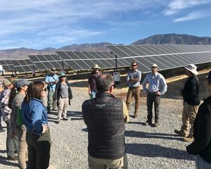 Group of people in discussion beside Nevada solar array