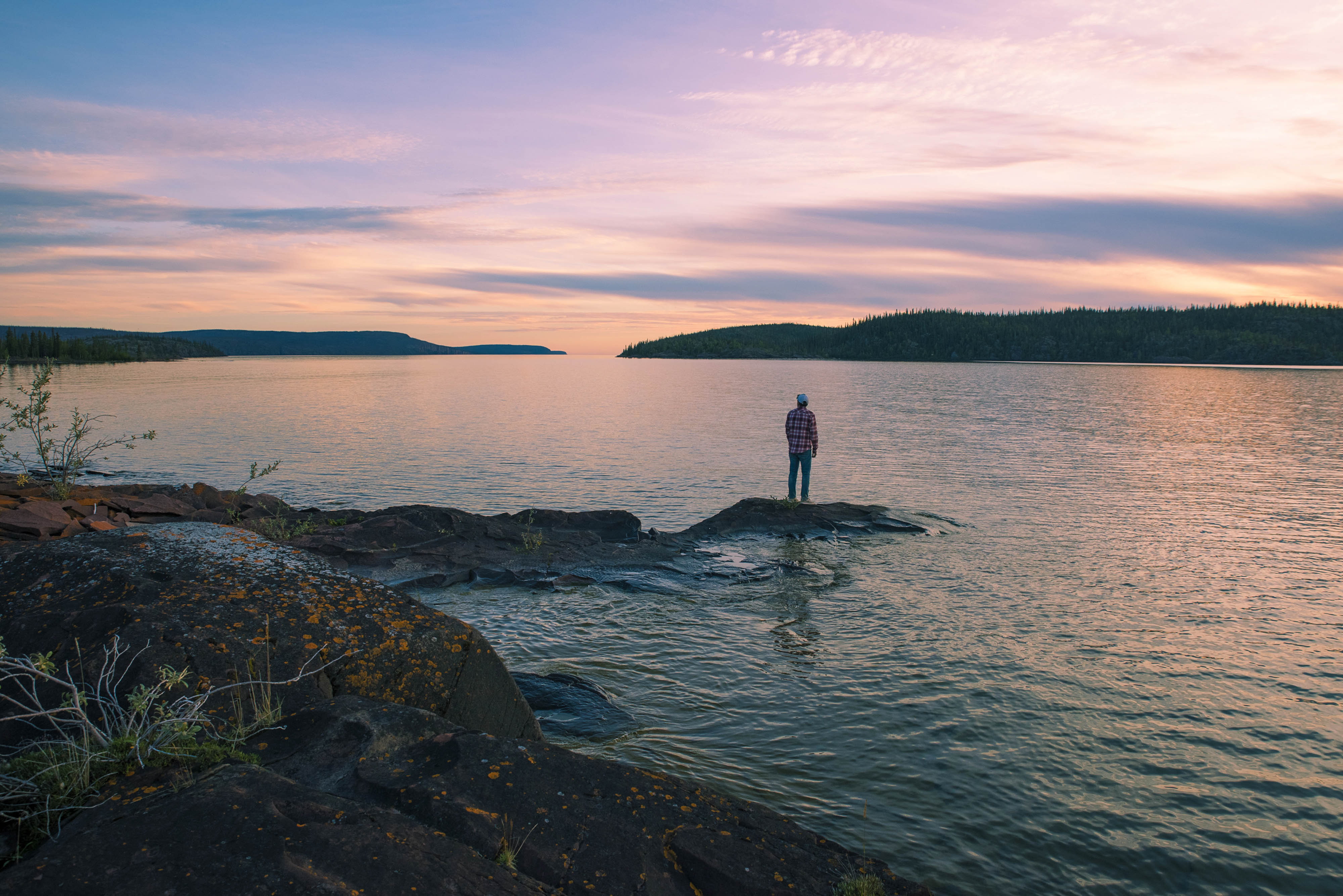 Ethan Rombough stands on a small island overlooking Christie Bay at the entry point of Thaidene Nëné National Park.