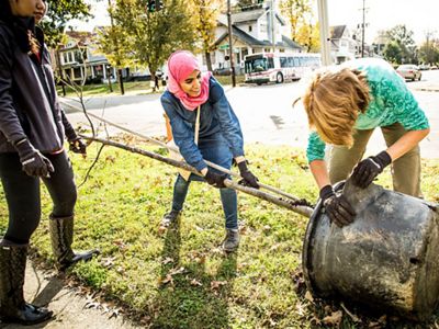 a group of youths sitting on a grassy hill.